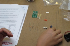 there is a PCB board, 3 LED's, 2 diodes, 2 switches, 8 resistors, 1 battery, 1 batter holder, 1 motor, 1 battery pack, 1 capacitor, 2 shrink tubes, and one charger port Laying out the materials